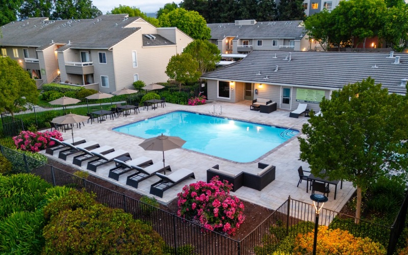 a swimming pool in a courtyard with lounge chairs